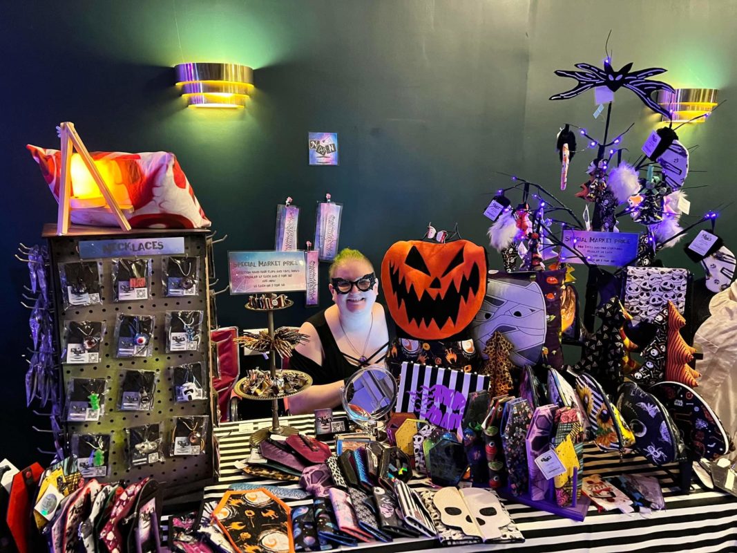 woman sitting behind full craft table